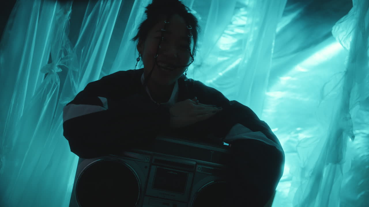 Joyful Asian Woman in Retro Tracksuit Dancing and Enjoying Music on Boombox