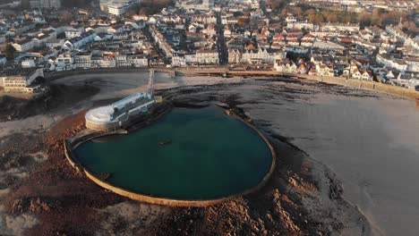 toma aérea inclinada hacia abajo, piscina havre de pas durante la marea baja, st helier, jersey, islas del canal, 4k
