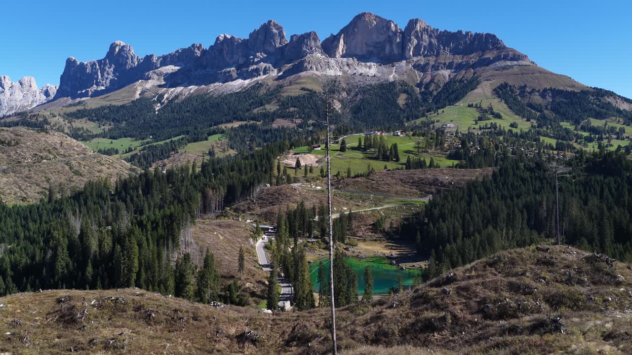 The Karersee Lago di Carezza, mountain lake in South Tyrol, Italy, near the Costalunga Pass. Aerial video. Latemar in the background
