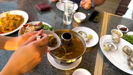 friends enjoying a meal with sour soup