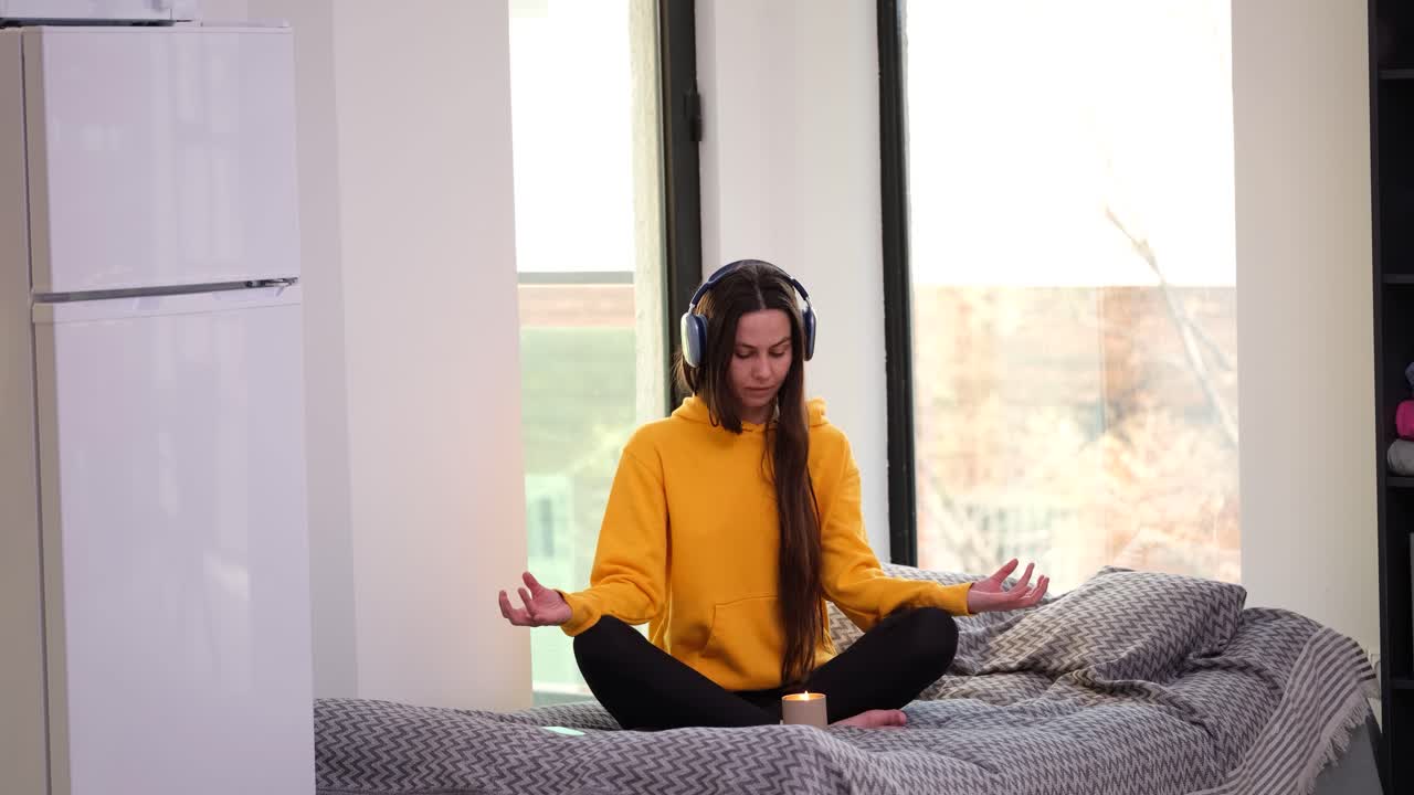 Woman Meditating with Headphones on Bed