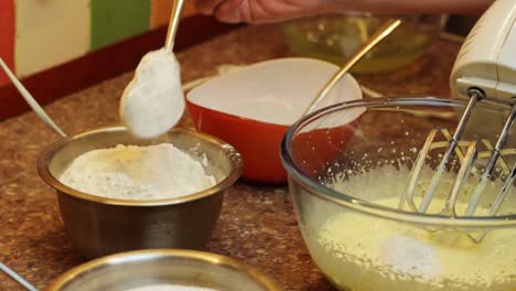 agregar harina a mano con una cuchara a la yema de huevo mezclada, preparación de bizcocho, primer plano