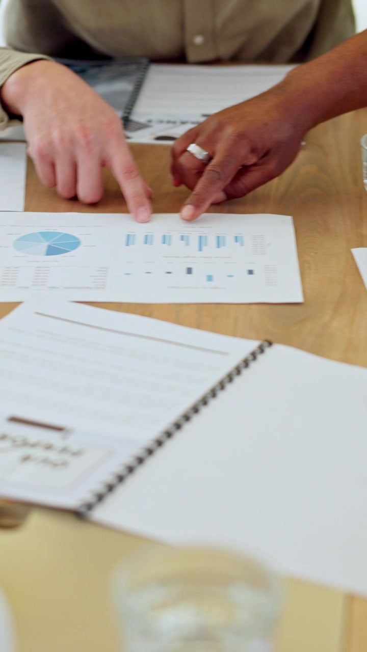 Colleghi di lavoro che esaminano grafici finanziari durante una riunione in ufficio