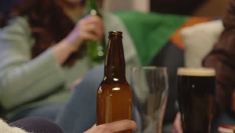 Close-Up-Of-Group-Of-Friends-Sitting-On-Sofa-At-Home-Or-In-Bar-Celebrating-St-Patrick's-Day-With-Party-Drinking-Alcohol-1