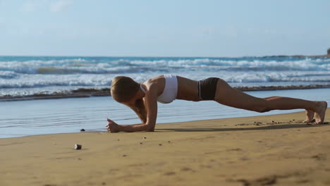 Vista-Lateral-De-Una-Hermosa-Mujer-Deportiva-En-Posición-De-Tabla-En-La-Playa-Durante-El-Atardecer.