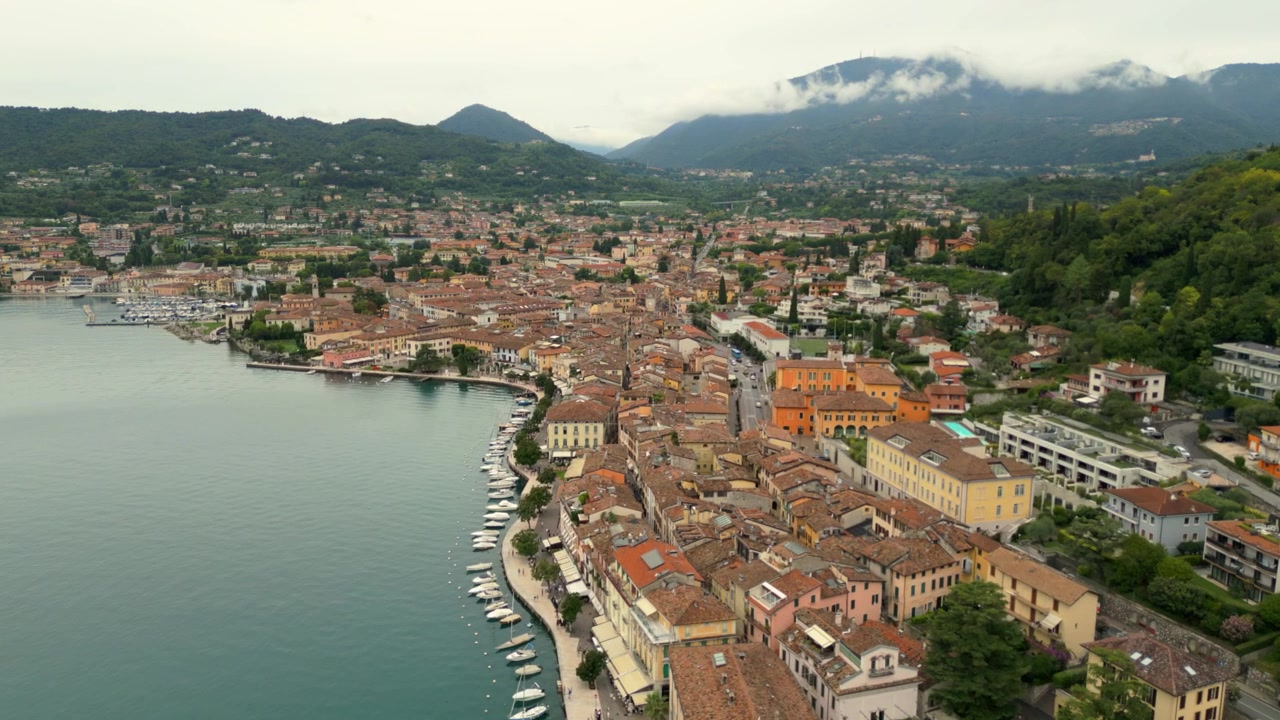 Vista aerea sul lungolago di Salò, città storica con barche ormeggiate lungo la riva del lago.