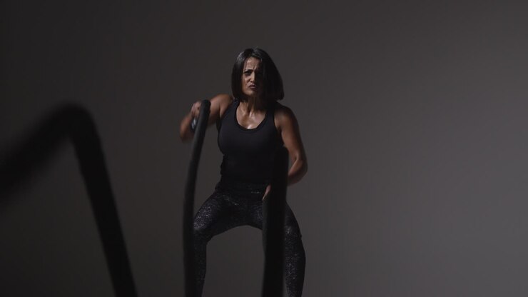 Studio Shot Of Mature Woman Wearing Gym Fitness Clothing Doing Cardio Exercise With Battle Ropes 3