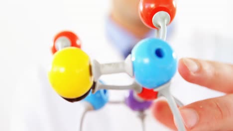 primer plano de un científico que sostiene un modelo de molécula