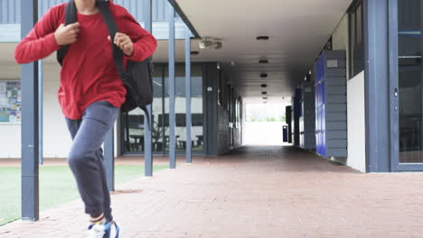 in a school corridor, a young student is running with copy space