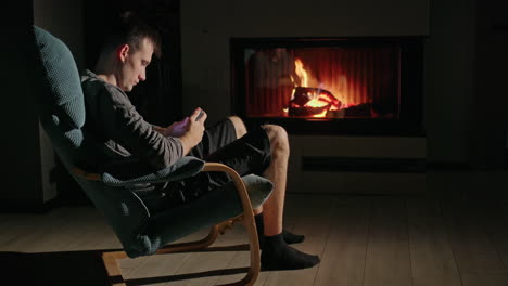 young man playing game by the fireplace