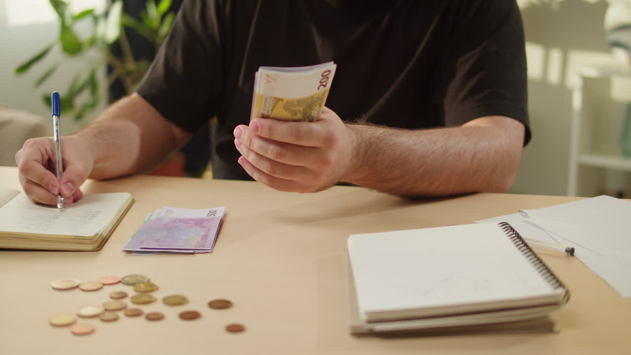 Uomo che conta banconote e monete in euro alla scrivania