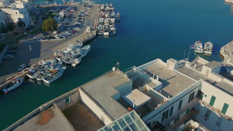 Modern-vessels-moored-at-the-quay-next-to-the-traditional-fishing-boats-in-the-port-of-Monopoli-in-Italy-on-a-sunny-day