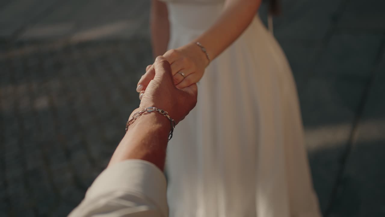 couple holds hands warmly in golden sunlight, evoking love and connection