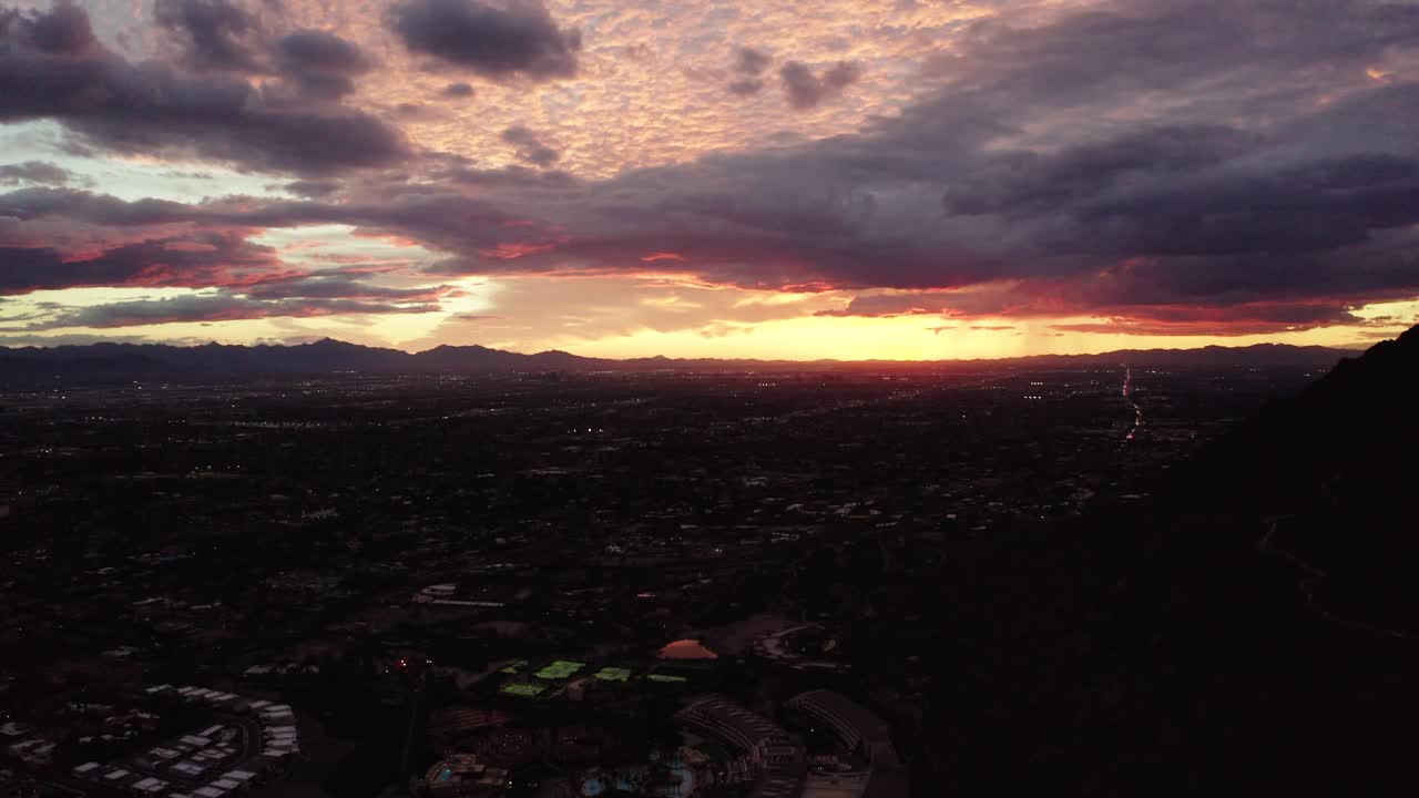Tilting down shot from pink Arizona skies to reveal sprawling neighborhoods