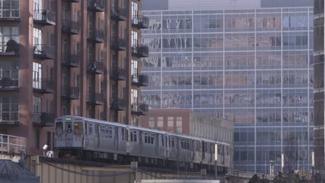 Totale-Aufnahme:-Ein-Sonniger-Tag-Fängt-Einen-Geschäftigen-U-Bahn-Zug-In-Chicago-In-Bewegung-Ein,-Mit-Wolkenkratzern-Im-Hintergrund