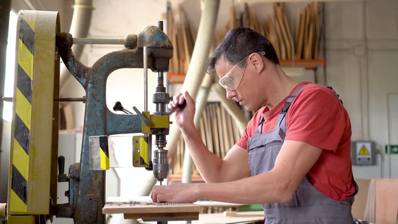Man operating a drill press in a woodworking workshop