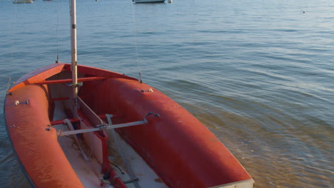 primer plano bloqueado de un pequeño bote de vela flotando suavemente sobre el agua