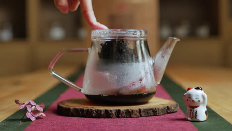 preparando té negro en una tetera de vidrio