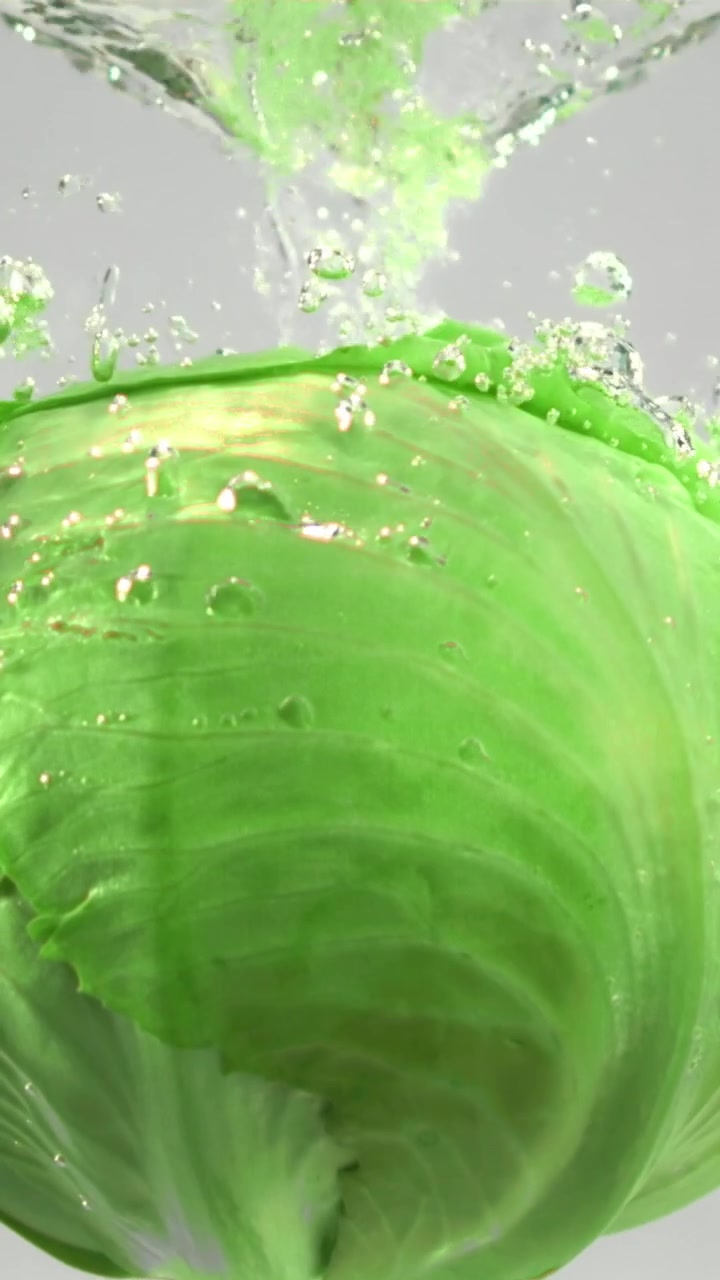 Cavolo verde fresco che si immerge in acqua limpida al rallentatore