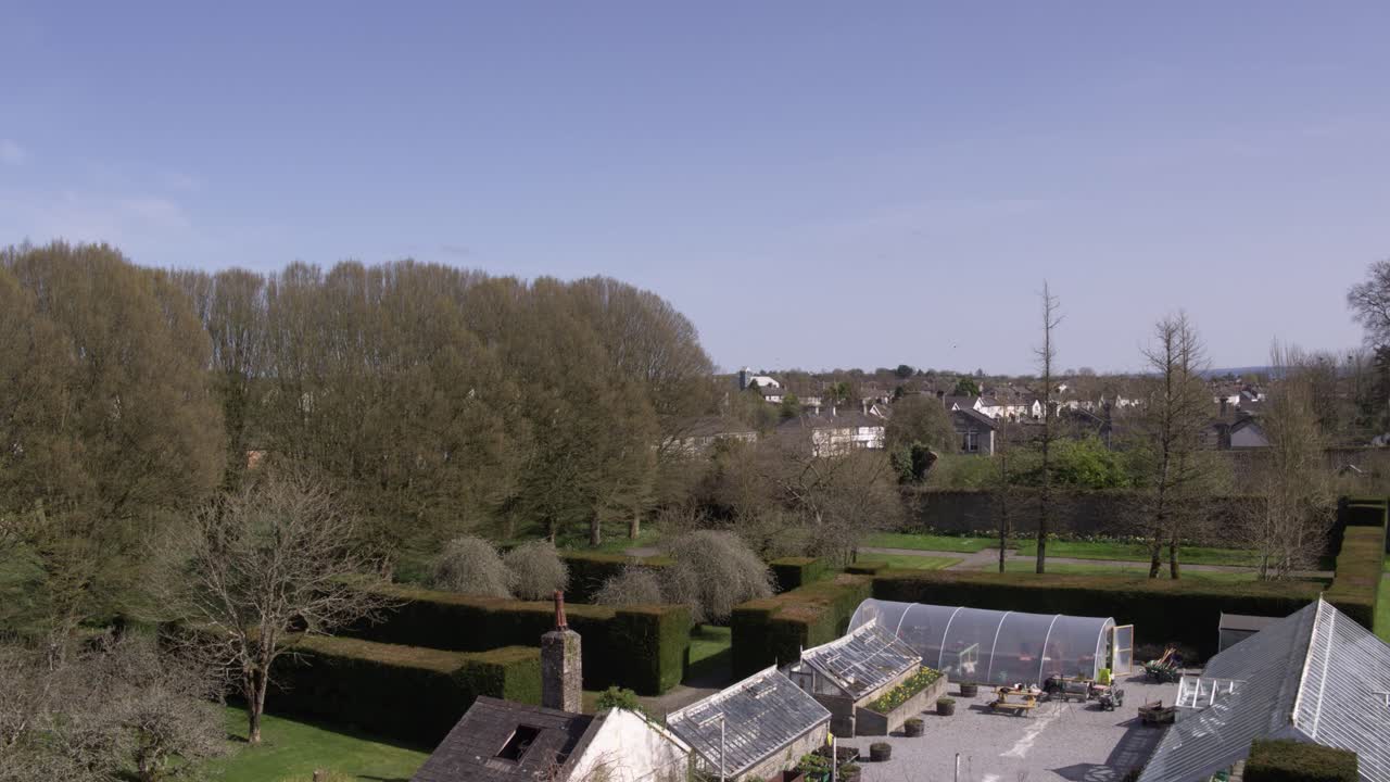 The blue skies over an Birr Castle Gardens, Co. Offaly. This drone shot slowly flies upwards to reveal the town and nature directly behind and beside it.