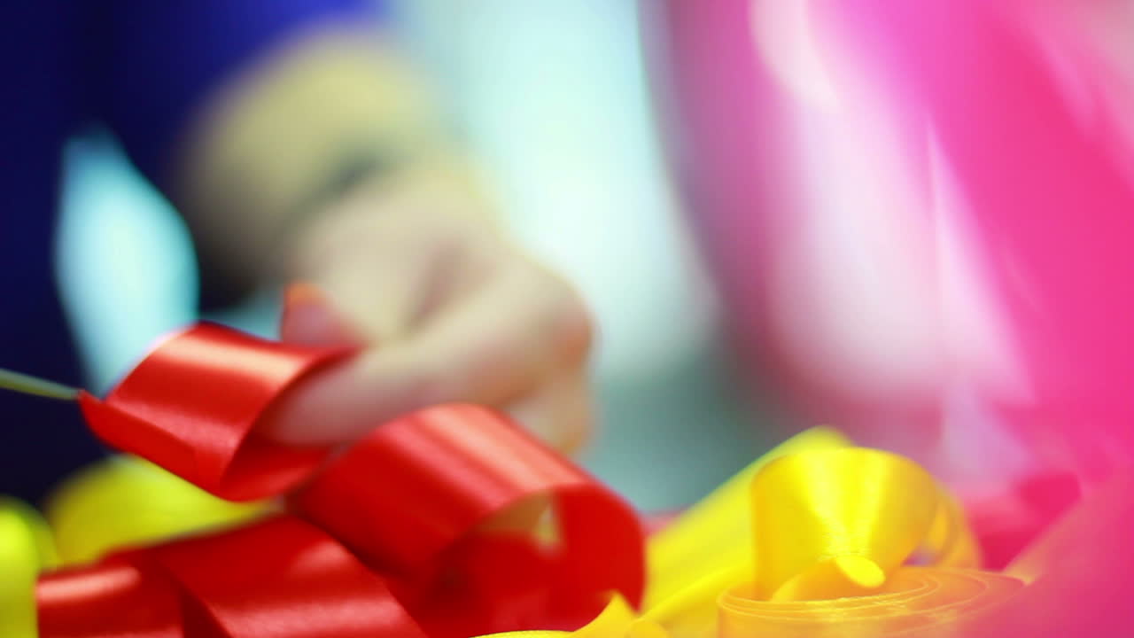 리본 장식. 빨간 리본을 자르는 손. 새틴 포장 테이프