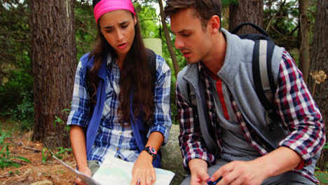 una pareja de excursionistas sentados y buscando su dirección