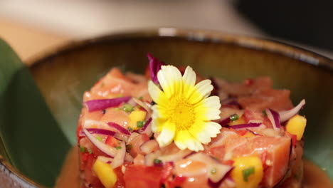 chef lifts the stainless moulder and reveals the tuna ceviche with a beautiful daisy flower