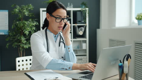 Doctor Consulting with Patient via Phone and Laptop