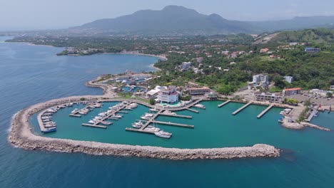 Aerial-establishing-shot-of-Marina-Ocean-World-in-Puerto-Plata-with-yachts-and-boats-during-sunny-day,-Dominican-Republic