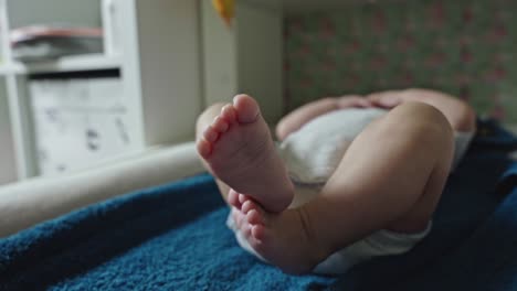 newborn baby moving legs while lying on changing table