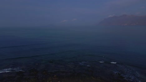 A panoramic view above Famara town on the Lanzarote Island, the Canary Islands, starting with the view at the Caleta de Famara houses and ending with ocean waves in the background.