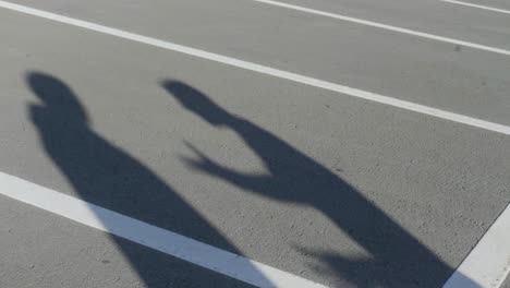 shadows of two people in a parking lot