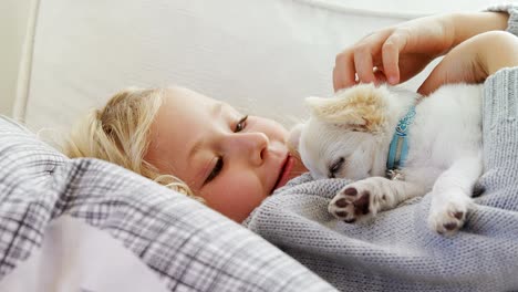 niña acostada en el sofá acariciando a su mascota en casa 4k 4k