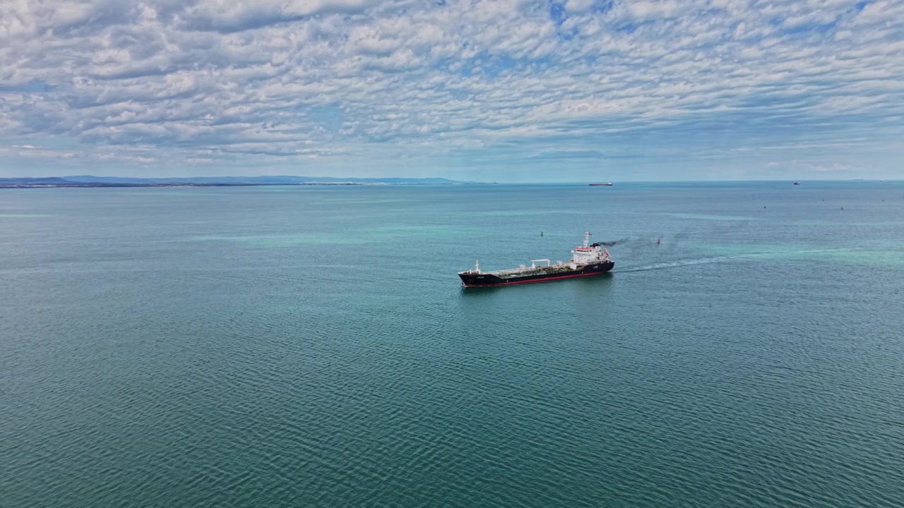 Nave che attraversa le acque calme della baia vicino alla costa