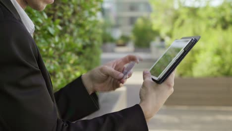 Young male hands putting bank card data on tablet, paying online