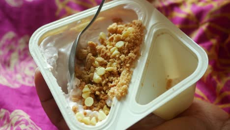 mixing granola musli with yogurt in container ,