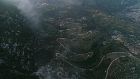 Aerial-Drone-Shot-Of-Winding-Road-By-Mountain-In-Remote-Lebanon