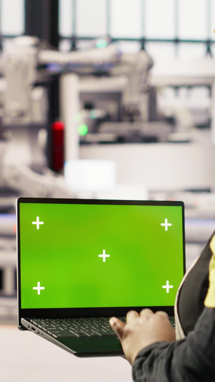 Vertical video Specialist using green screen laptop to conduct inspection in industry 4.0 plant