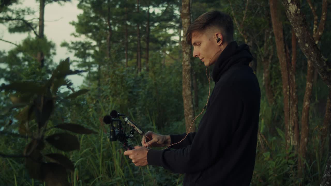Man filming video in forest