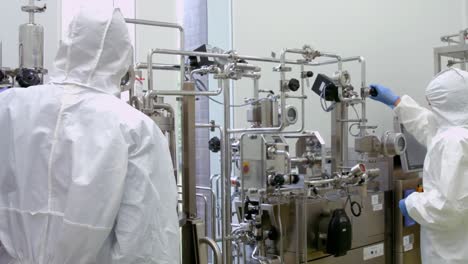 scientists in protective suits working on vat