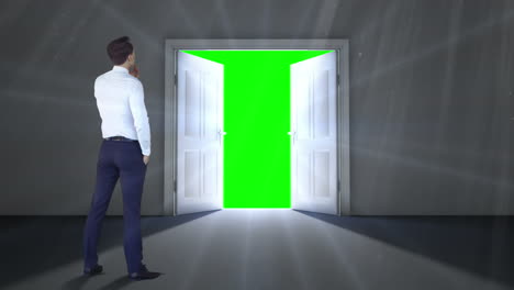 Door opening to green screen watched by businessman