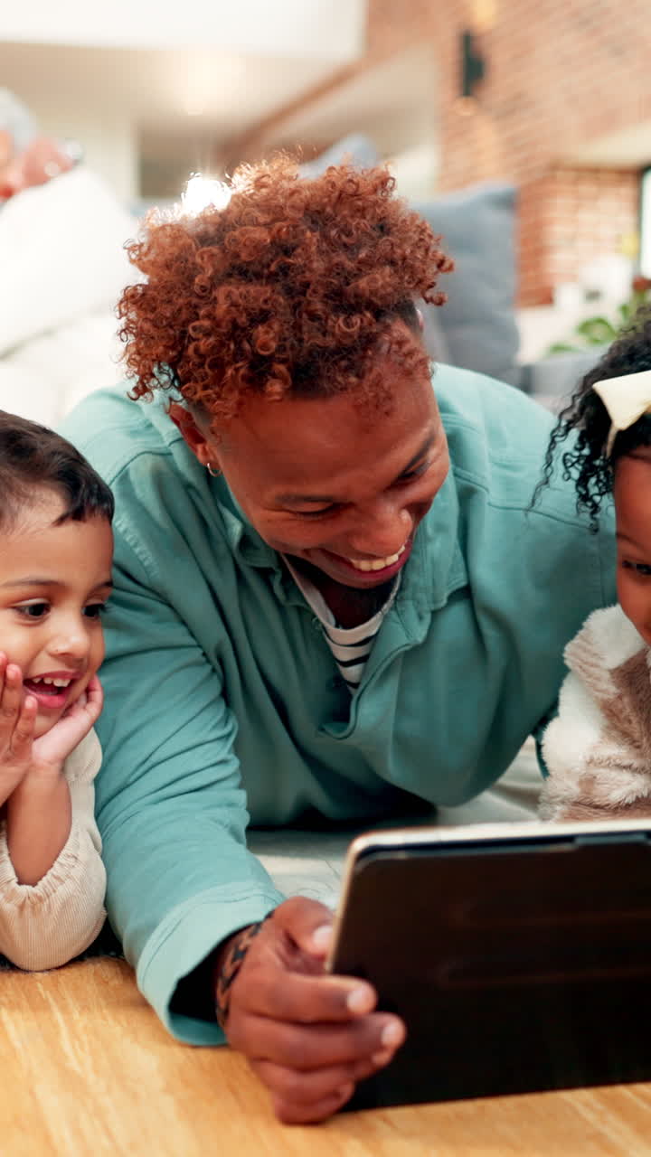 Padre e figli felici che ridono mentre guardano il tablet a casa