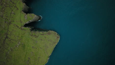 aerial view of green cliffs and blue ocean