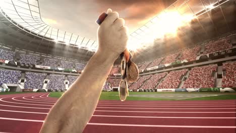 hand of athlete showing gold medals in olympic stadium