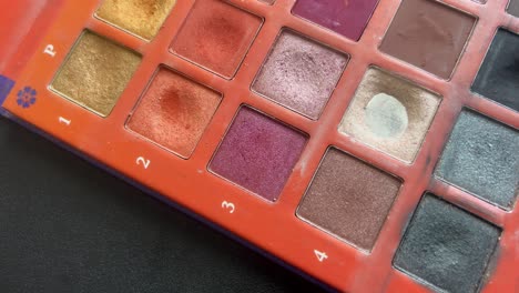 Nahaufnahme-Eines-Make-up-Pinsels,-Der-Sanft-über-Einem-Hellbraunen-Lidschatten-In-Einer-Farbenfrohen-Palette-Wirbelt