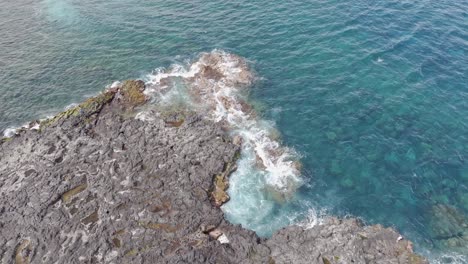 Drone-view-of-Pointe-au-Sel-in-Saint-Leu,-Reunion-Island,-showcasing-water-and-rocks,-with-a-gentle-rotating-right-movement