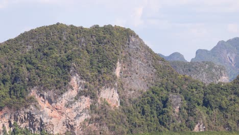 a serene view of lush, green mountains under a bright sky, captured with smooth camera movement in phang nga, thailand