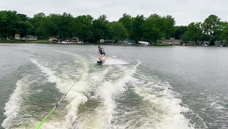girl wakeboarding on summer day at the lake