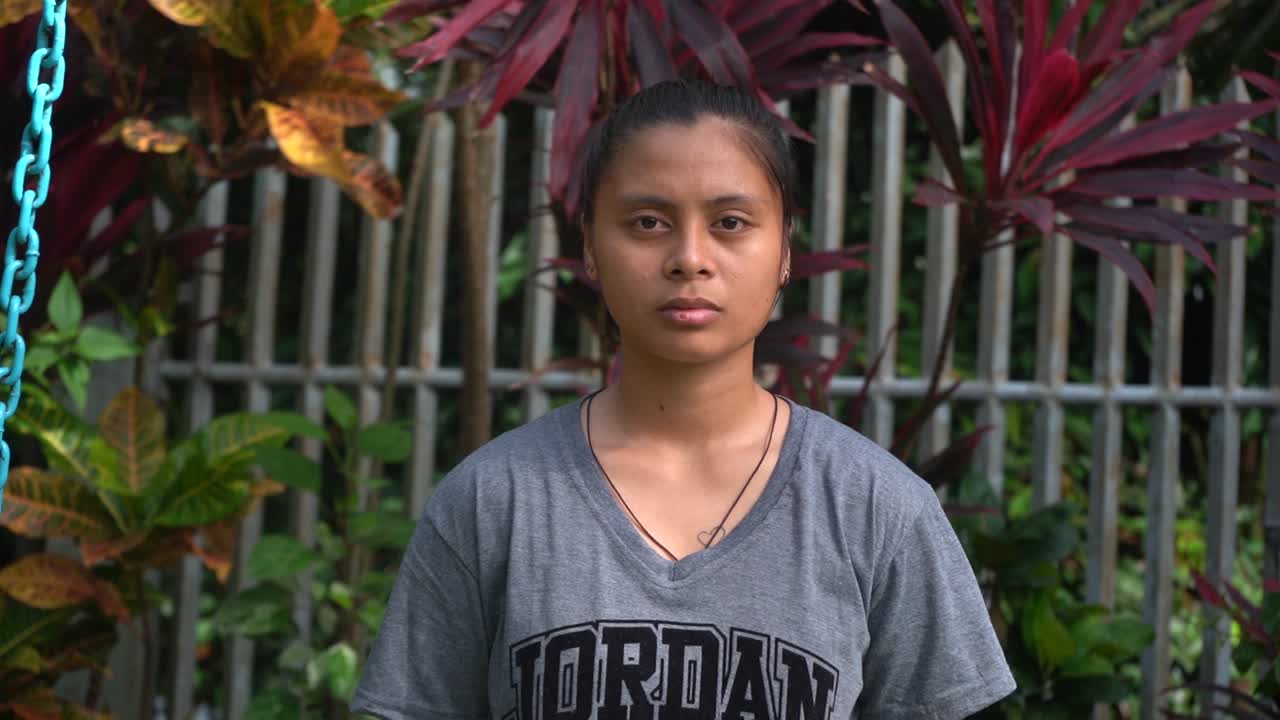 근면하고 친절한 필리핀 고아 소녀가 필리핀의 고아원 집에서 카메라를 슬프고 외롭게 바라보고 있습니다 - 중간 샷