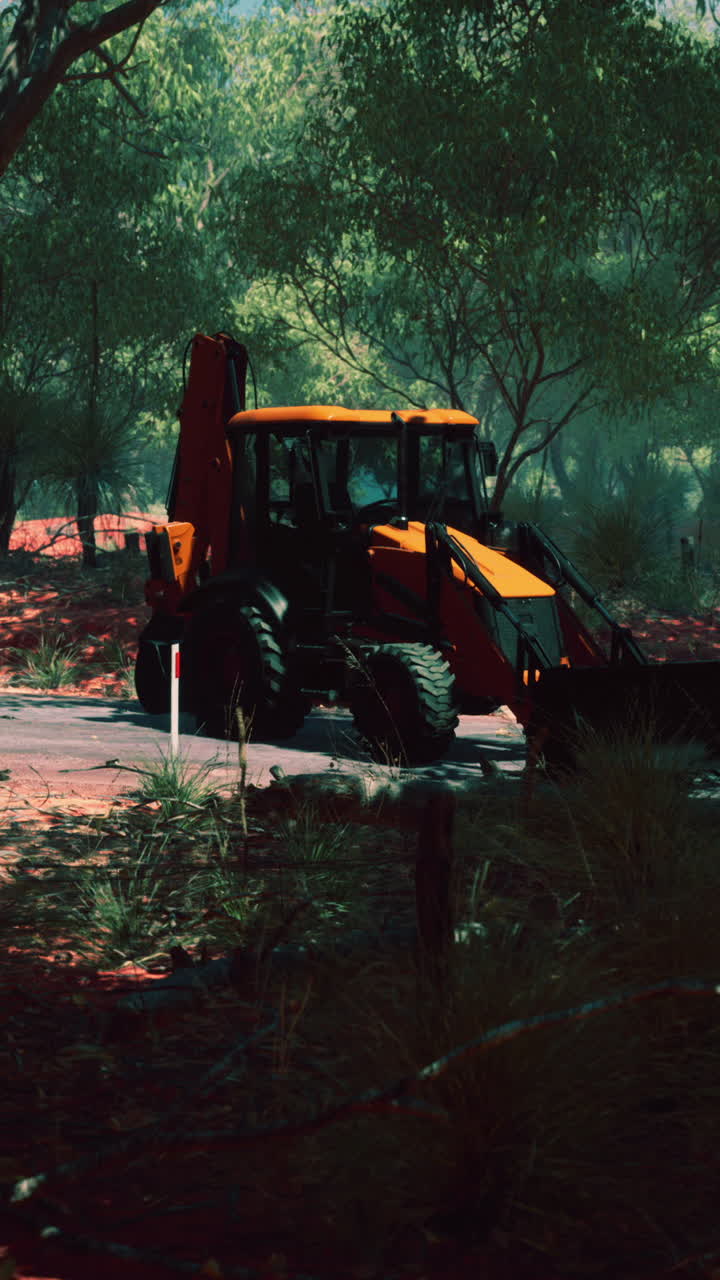 오스트레일리아 덤불 의  도로 에 주차 된 노란색 발굴기